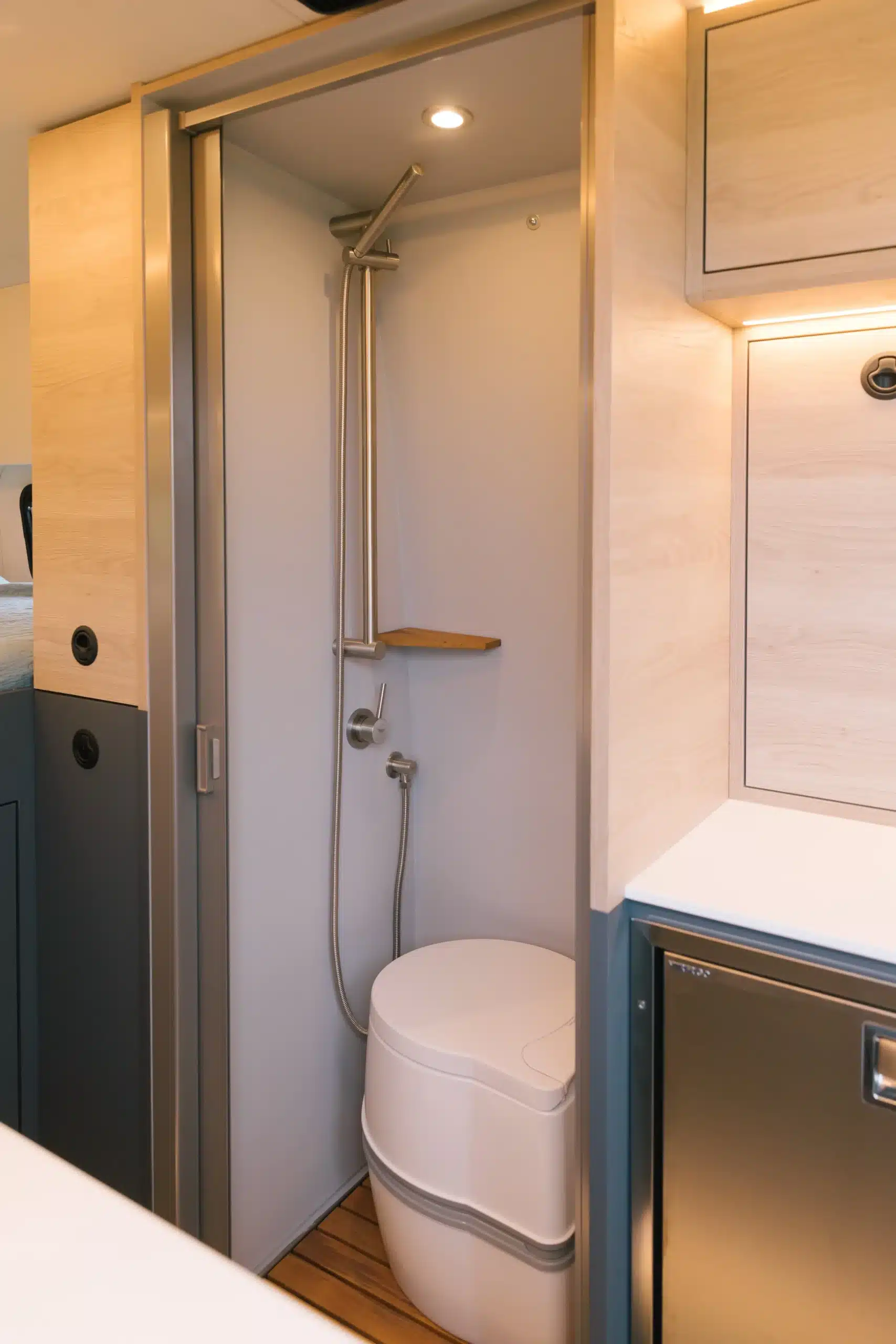 Innenansicht des Badezimmers im Mercedes Sprinter 170 4x4 Cuddy mit Dusche und tragbarer Toilette