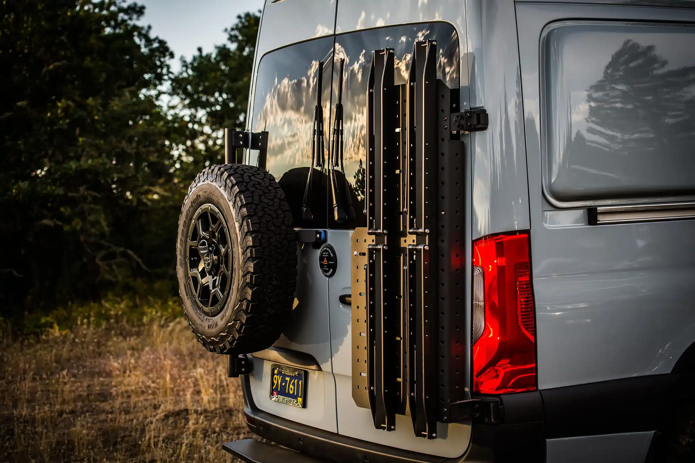 Heck eines Mercedes Sprinter 4x4 Azure mit montiertem Reserverad und Offroad-Transporthalterungen