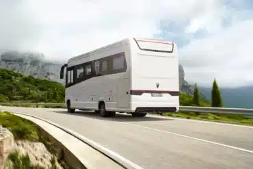 Heckansicht eines Morelo LOFT Liners auf einer kurvigen Bergstraße mit bewaldeten Hügeln und Wolken im Hintergrund