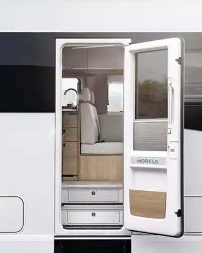 Geöffnete Tür eines Morelo Palace Reisemobils mit Blick auf den hellen Innenraum und Sitzgruppe