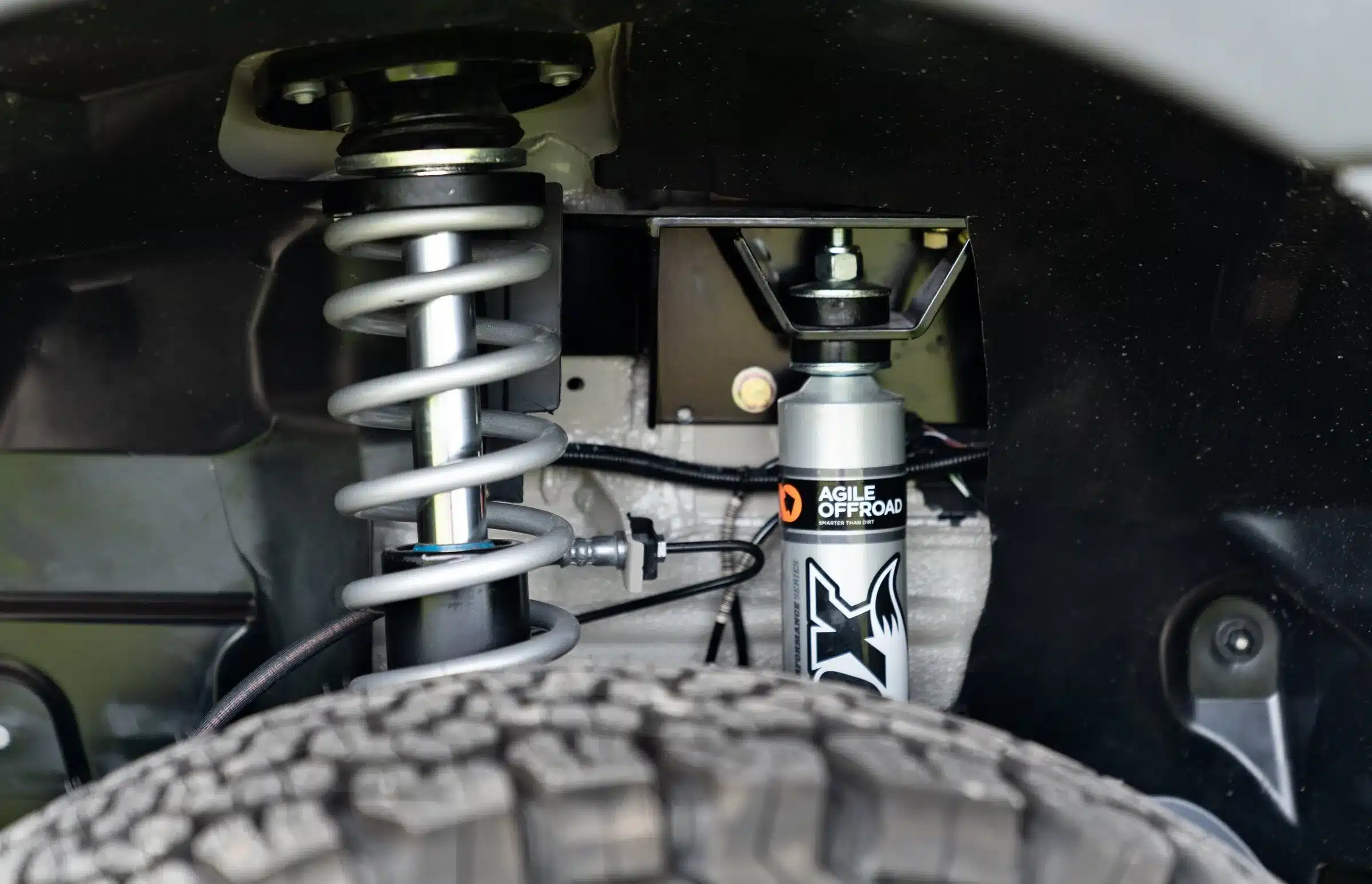 Nahaufnahme einer Offroad-Federung und Stoßdämpfer im Radkasten eines Mercedes Sprinter Vans