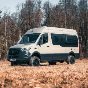 Rhön Camp THE FORCE Campervan auf Basis eines Mercedes Sprinter, stehend auf einer Wiese vor einem Wald
