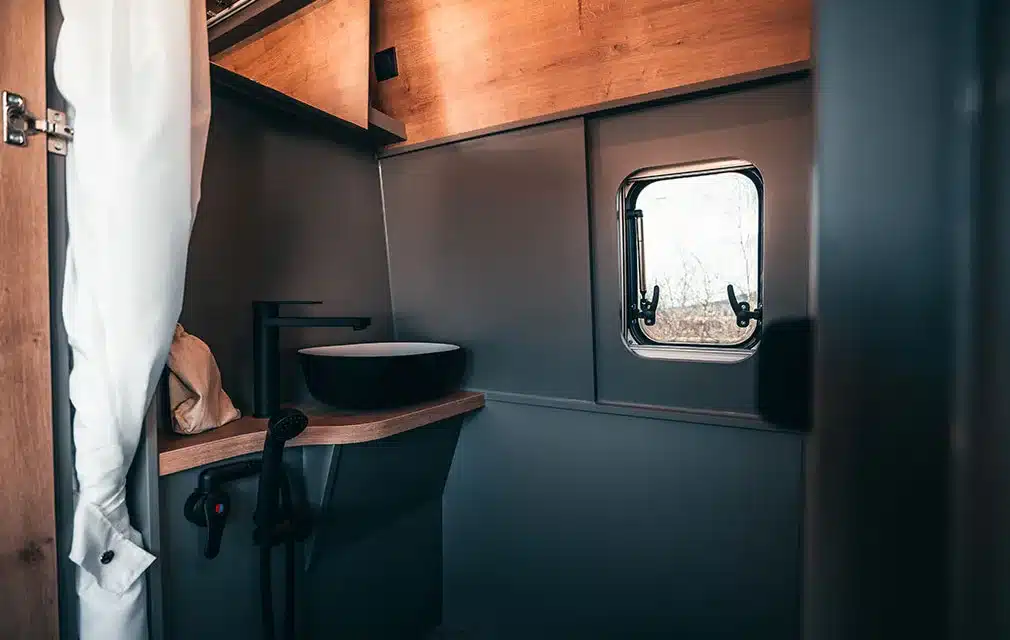 Innenansicht des Badezimmers im Rhön Camp THE FORCE mit Waschbecken, Fenster und Holzdetails