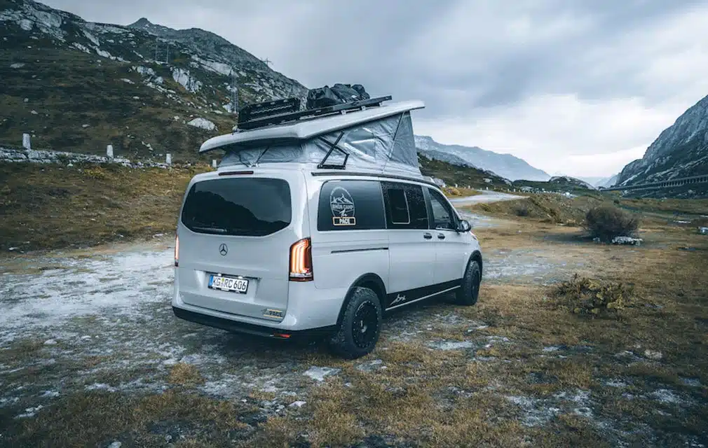 Rhön Camp The Pace Campervan mit geöffnetem Aufstelldach auf Mercedes Vito Basis in alpiner Landschaft