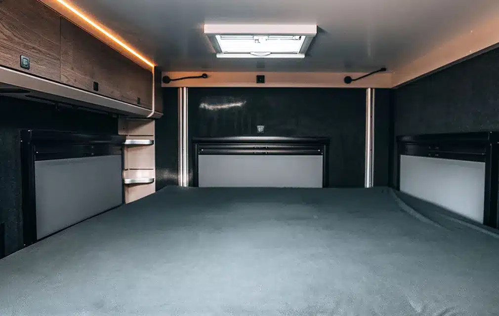 Innenansicht des absenkbaren Längsbetts im Rhön Camp The Renegade Campervan mit Dachluke und Stauraum