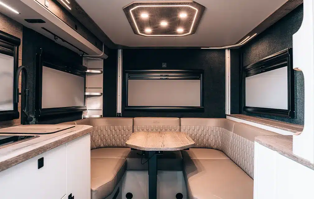 Großzügige Hecksitzgruppe mit Tisch und moderner LED-Beleuchtung im Campervan Rhön Camp The Renegade