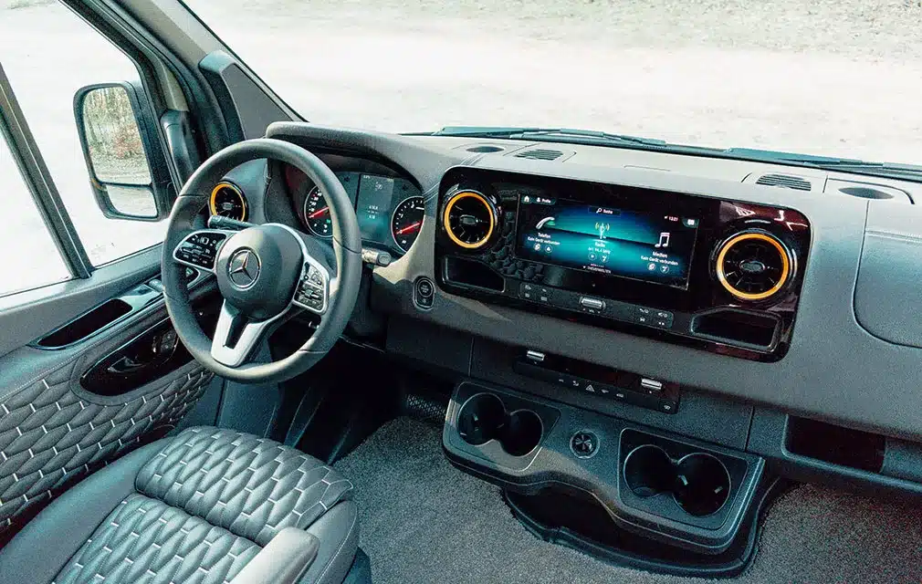 Innenansicht des Cockpits vom Rhön Camp The Specter mit Mercedes-Benz Lenkrad, großem Display und Ledersitzen