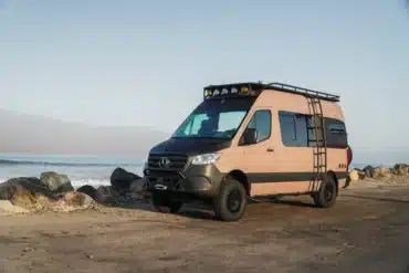Rob Machado Surf Van Rogue Wave, ein ausgebauter Mercedes Sprinter mit Offroad-Elementen, steht am Strand vor dem Meer