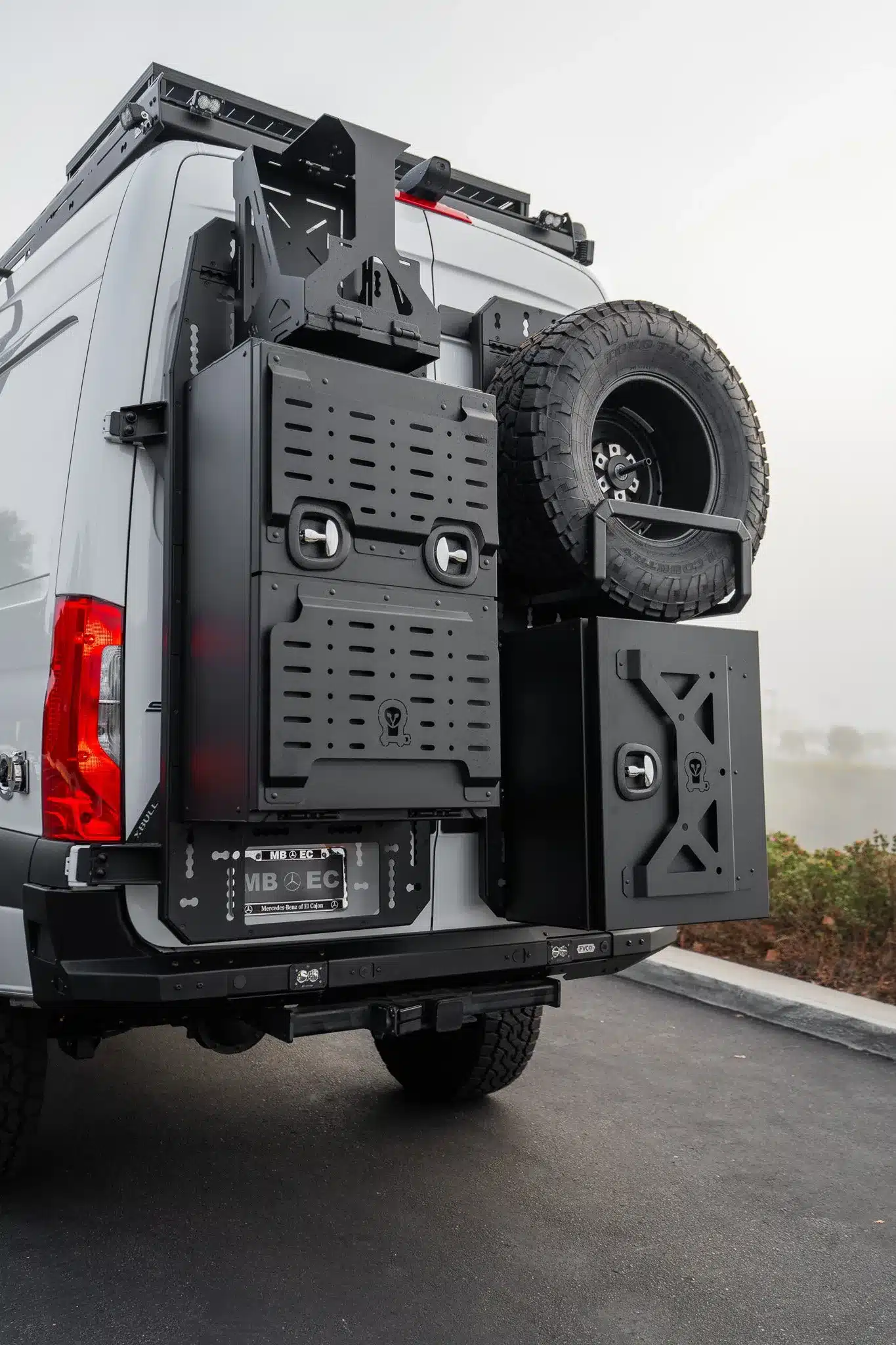 Heckansicht eines ausgebauten Rogue Stratos Campervans mit Reserverad, Stauboxen und Offroad-Zubehör.