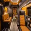 Luxuriös ausgebauter Innenraum eines Rogue Stratos Campervan mit Zedernholzdecke, Lederpolstern und moderner Beleuchtung