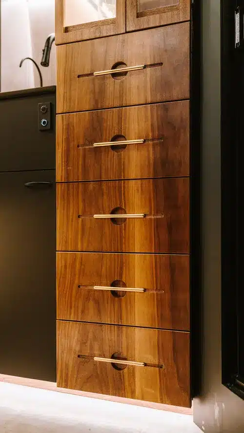 Detailansicht von Schubladen aus Walnussholz mit Messinggriffen im Innenraum eines ausgebauten Kastenwagens