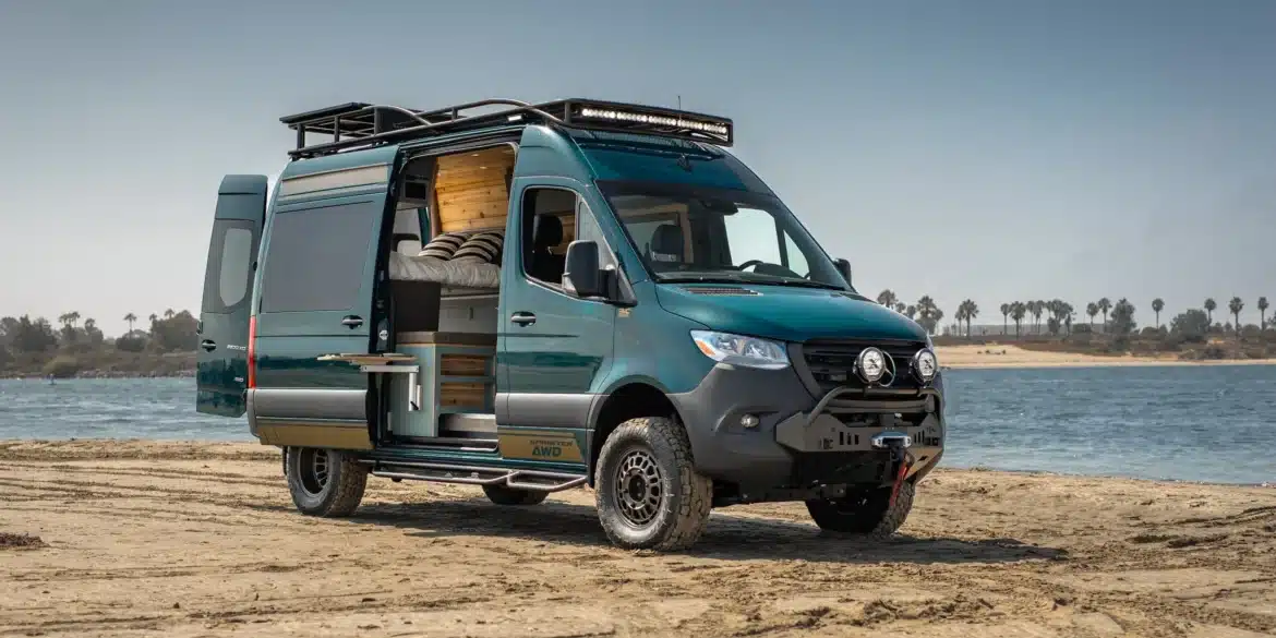 Rogue Vans Overlander Campervan mit geöffneten Türen am Strand, Blick auf den Innenausbau und das Flarespace-Bett
