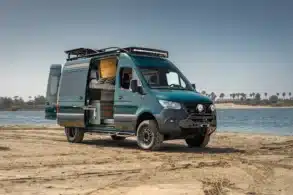 Rogue Vans Overlander Campervan mit geöffneten Türen am Strand, Blick auf den Innenausbau und das Flarespace-Bett