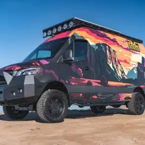 Rogue Vans Summer Classic Campervan mit bunter Folierung und Offroad-Ausstattung am Ufer eines Sees