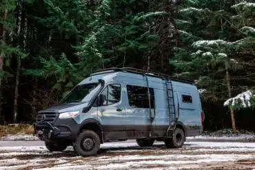Ronin Campervan auf Basis eines Mercedes Sprinter 170 EXT 4x4 mit Offroad-Umbau, Dachträger und Leiter, geparkt im verschneiten Wald