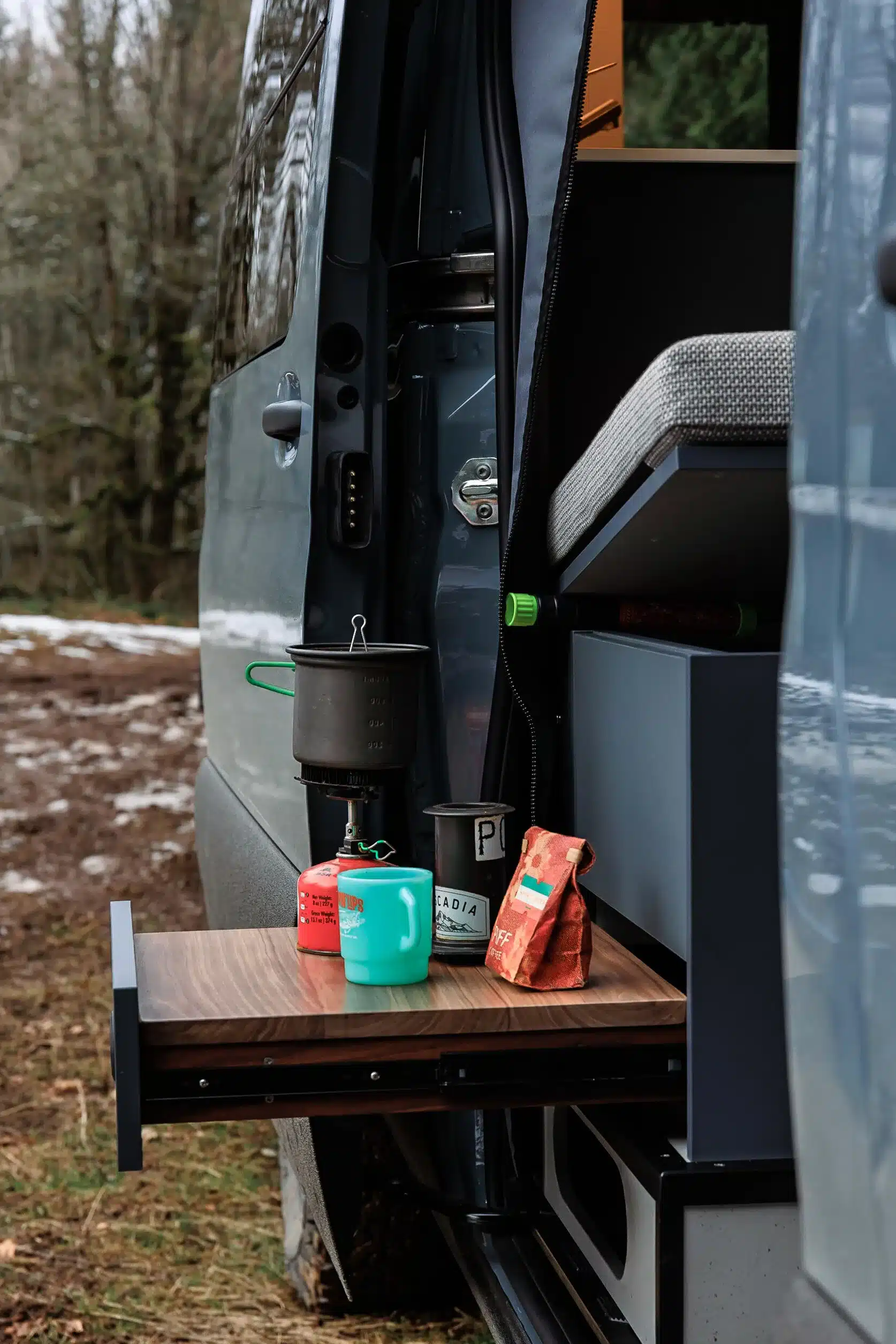 Ausziehbare Küchenzeile mit Gaskocher, Tasse und Kaffeepackung im Mercedes Sprinter Campervan