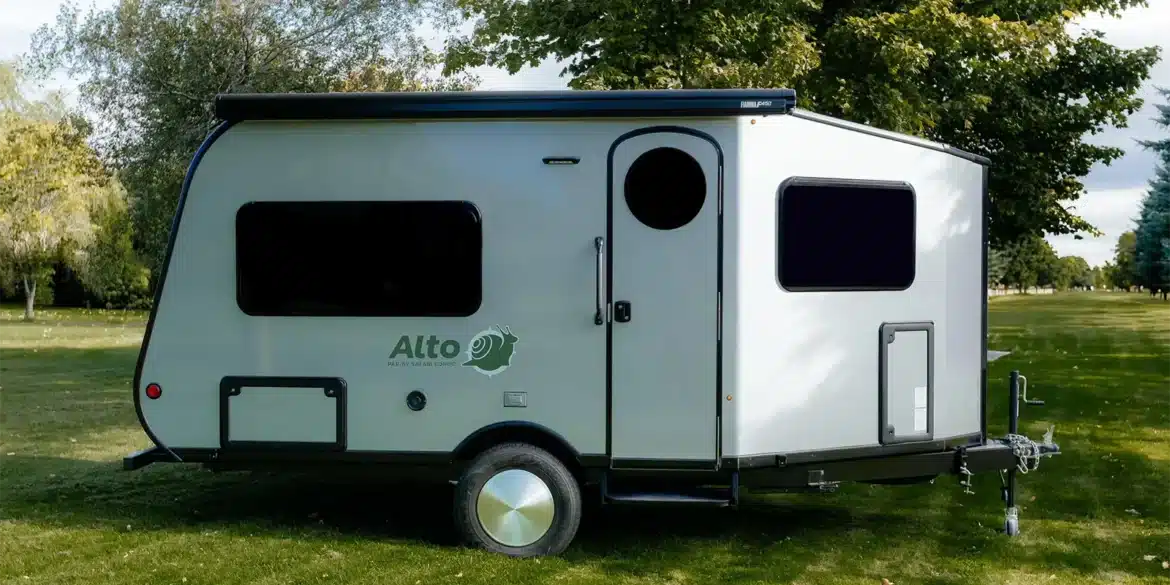 Seitenansicht des Safari Condo Alto A1752 Wohnwagens auf einer Wiese mit Bäumen im Hintergrund