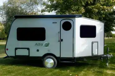 Seitenansicht des Safari Condo Alto A1752 Wohnwagens auf einer Wiese mit Bäumen im Hintergrund