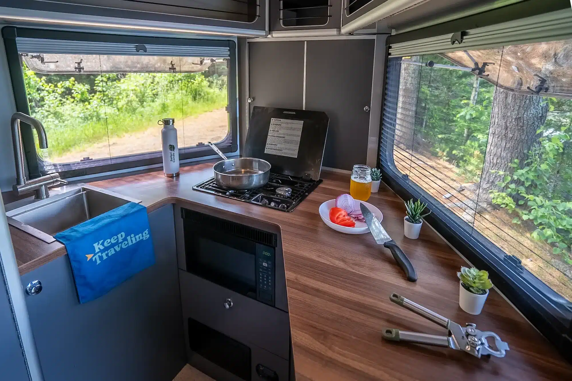 Innenansicht der Frontküche im Safari Condo Alto A1752 mit großem Fenster, Gaskocher, Spüle und Arbeitsfläche