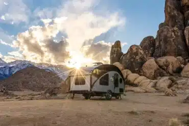 Safari Condo Alto R1713 Wohnwagen steht vor Felsen und Bergen bei Sonnenuntergang