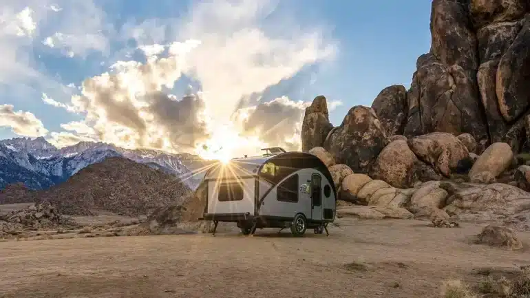 Safari Condo Alto R1713 Wohnwagen steht vor Felsen und Bergen bei Sonnenuntergang