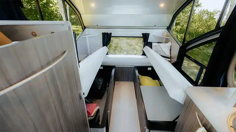 Innenansicht des Safari Condo Alto R1713 Trailers mit zwei Einzelbetten, Stauraum und großen Fenstern