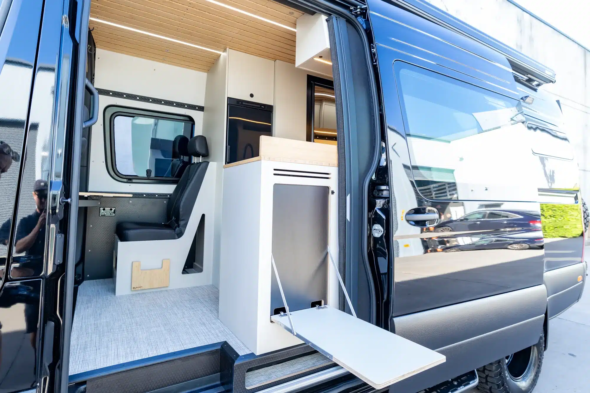 Blick in den Innenraum eines SUMMIT L1 4x4-Offroad-Reisemobils mit Sitzbank, Küchenmodul und moderner Ausstattung