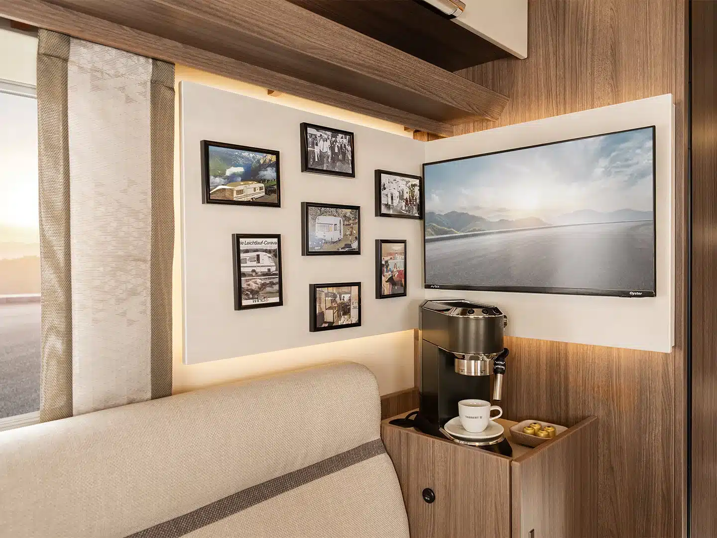 Innenraum des TABBERT Cazadora mit Fotowand, Fernseher, Kaffeemaschine und gemütlicher Sitzecke