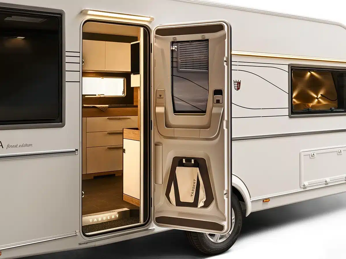 Geöffnete Tür eines Tabbert Pantiga Finest Edition Wohnwagens mit Blick auf die hochwertige Innenausstattung und Küche