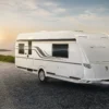 Tabbert Puccini Wohnwagen von außen mit markantem Design, modernen LED-Rückleuchten und Zugfahrzeug bei Sonnenuntergang
