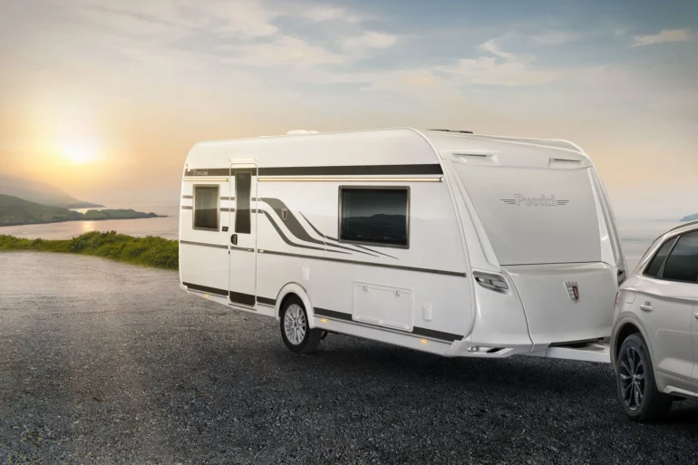 Tabbert Puccini Wohnwagen von außen mit markantem Design, modernen LED-Rückleuchten und Zugfahrzeug bei Sonnenuntergang