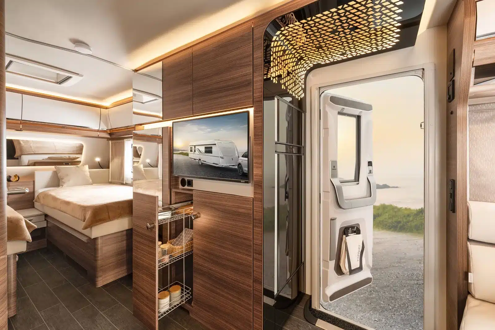 Innenansicht eines Tabbert Puccini Wohnwagens mit modernem Holzdekor, breitem Bett, innovativem Lichtdesign und offener Tür mit Blick nach draußen