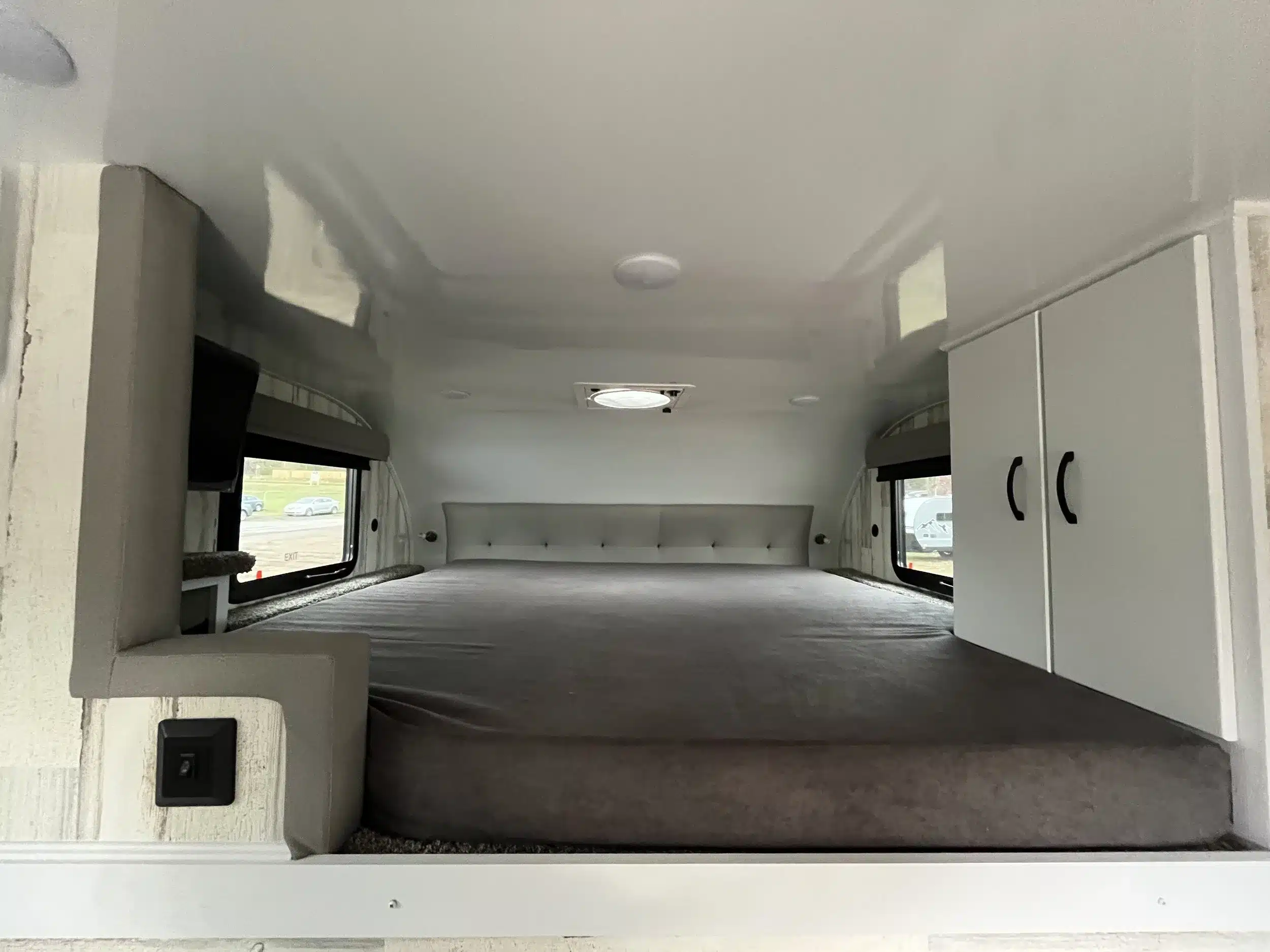 Schlafbereich mit großem Bett, Fenstern und Schränken im TC14 Truck Camper von Modern Buggy RV