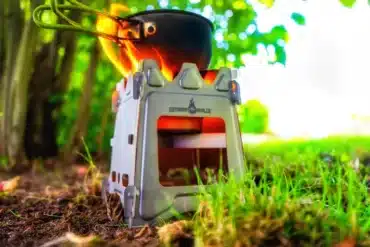 Outdoor-Kocher Titan Hobo V2 Pro von Outdoor Ninja mit Topf und Flamme im Grünen