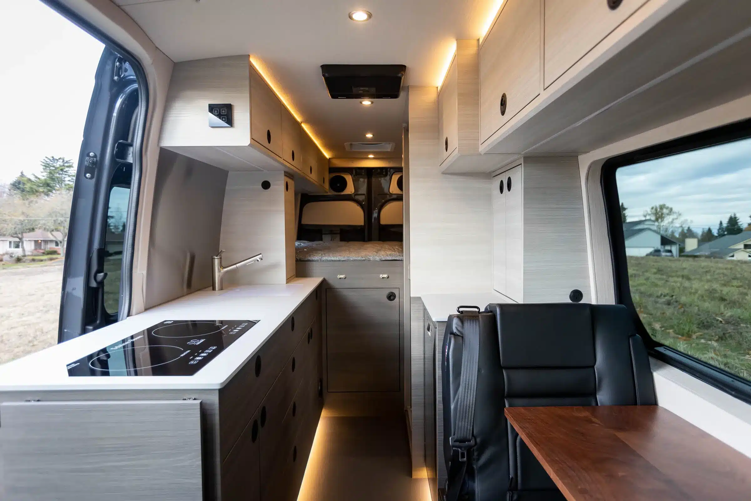 Hochwertig ausgebauter Innenraum eines Tralfamadore 4x4 Sprinter Campers mit Küche, Sitzbank und Bett