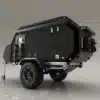 Schwarzer Valkari X1 Offroad-Caravan mit großen Reifen, Schaufeln an der Seite und robustem Aufbau auf hellem Hintergrund