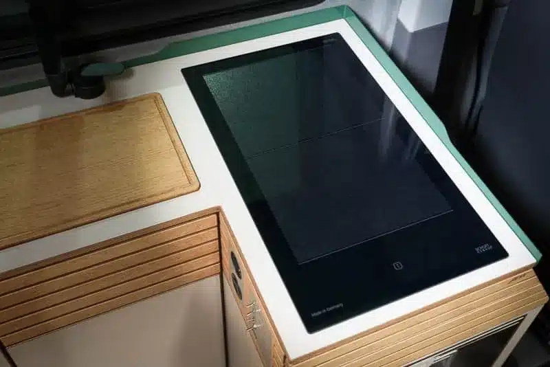 VANING Induktionskochfeld eingebaut in eine Campervan-Küche mit Holzarbeitsfläche