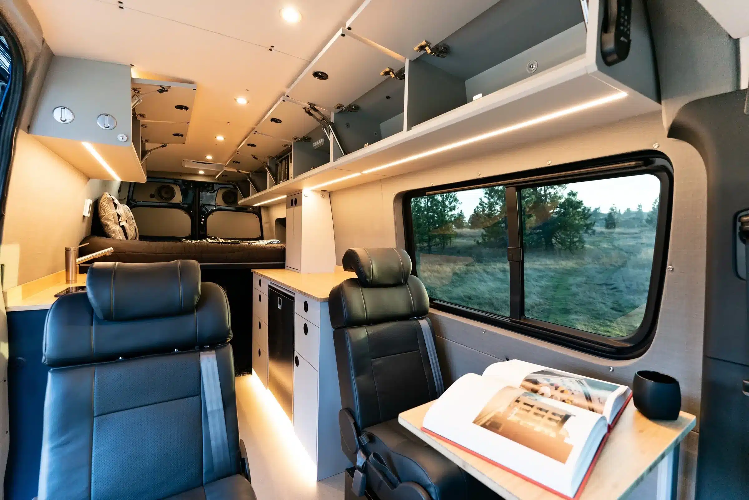 Innenansicht eines ausgebauten Mercedes Sprinter 170 4x4 mit Bett, Sitzplätzen, Stauraum und Küchenzeile
