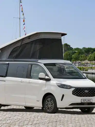 Weißer Westfalia Kipling Campervan mit geöffnetem Aufstelldach steht am Hafen neben Segelbooten