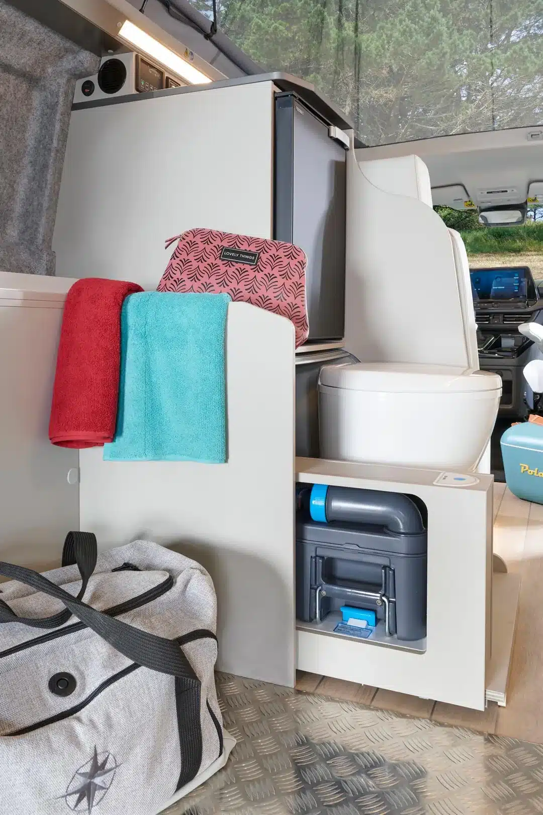 Detailaufnahme des Innenraums im Westfalia Kipling Campervan mit Kühlschrank, Toilette und Gepäck