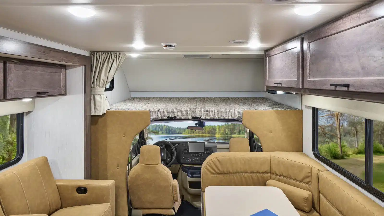 Innenansicht eines Winnebago Minnie Winnie NPF Wohnmobils mit Sitzgruppe, Fahrerhaus und Alkovenbett