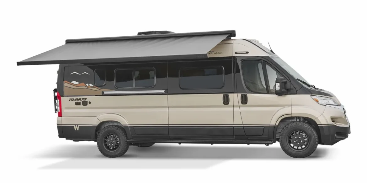 Seitenansicht eines beige-schwarzen Winnebago Travato Kastenwagen-Campers mit ausgefahrener Markise