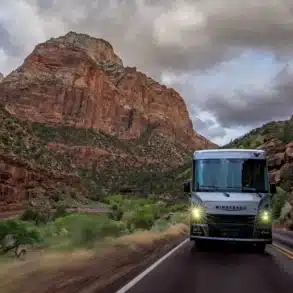 Frontansicht eines Winnebago Vista NPF Wohnmobils auf einer Straße durch eine felsige Nationalpark-Landschaft