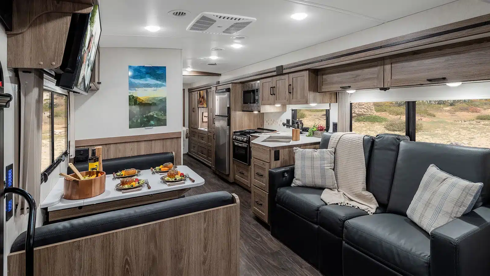 Moderner Innenraum eines Winnebago Vista NPF Wohnmobils mit Sitzgruppe, Küche und Sofa