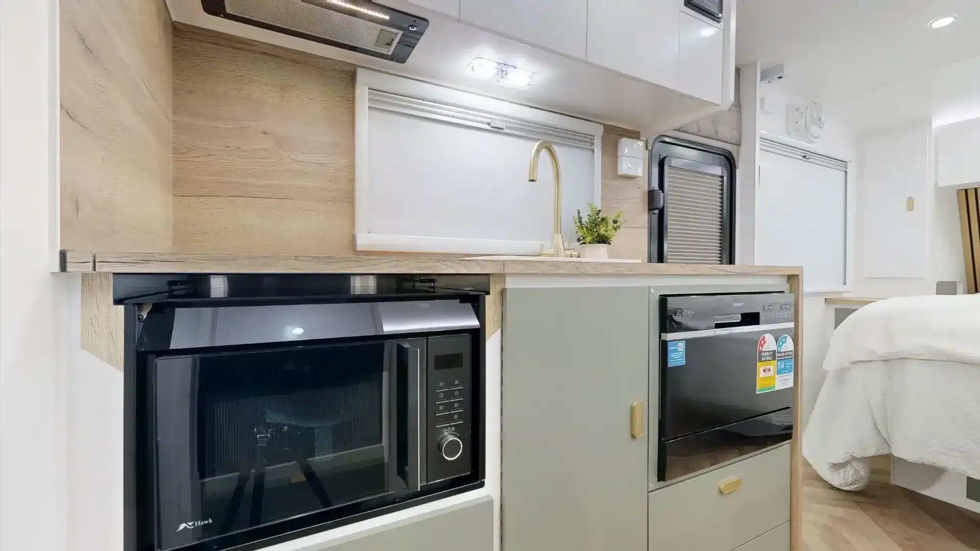 Innenansicht der Küche im Zeus Quad Bunk Caravan mit Ofen, Spüle und Kühlschrank