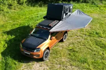 Van mit ausgeklappter 180-Grad-Markise auf einer Wiese, aufgenommen aus der Vogelperspektive