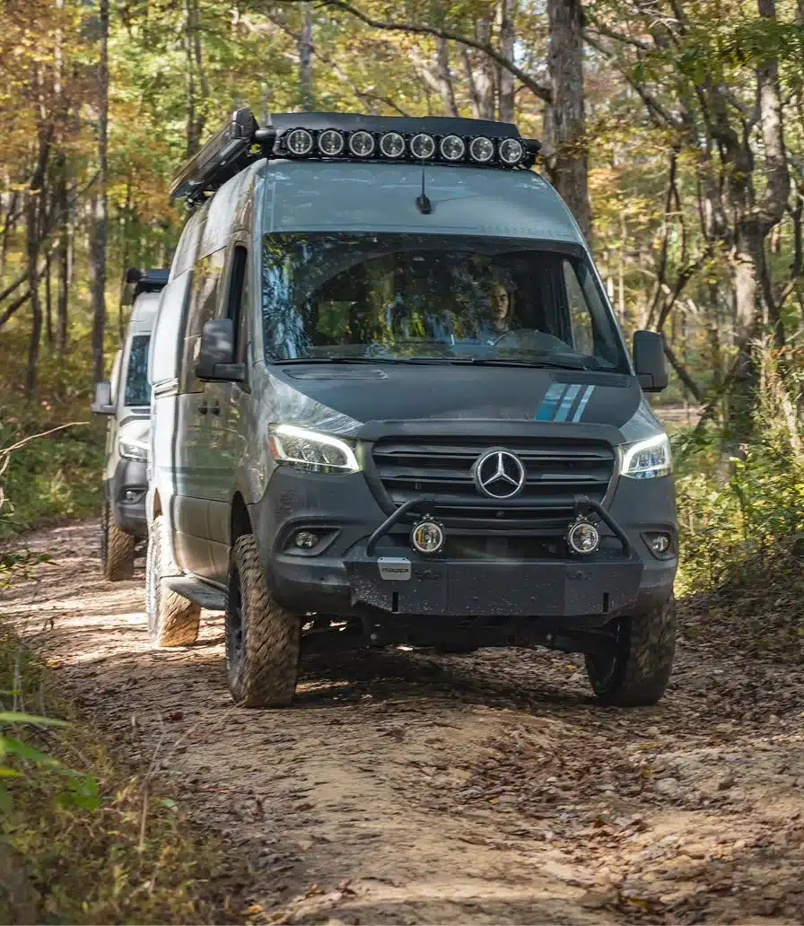 Der 2026 Beast Mode XO Kastenwagen von Storyteller Overland mit Offroad-Ausstattung, gefahren auf einem schlammigen Waldweg