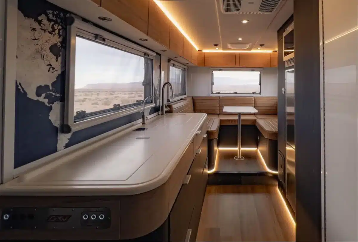 Innenansicht des GXV Hilt Expeditionsfahrzeugs mit großzügiger Küchenzeile, Sitzgruppe und Stauraum.