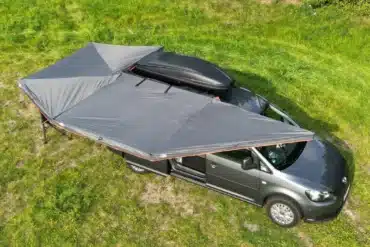 Campervan mit ausgefahrener 270 Grad Markise Xtended auf einer Wiese, Vogelperspektive