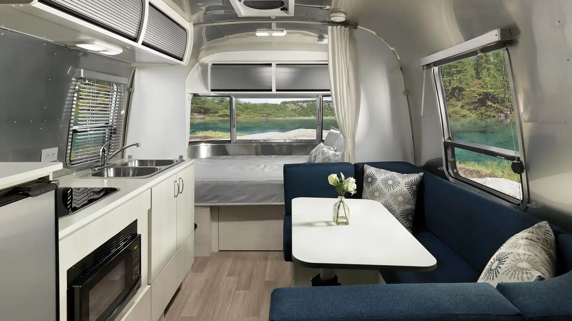Airstream Bambi 20FB Innenraum mit Kücheneinheit, Sitzgruppe und Bett im kompakten US-Caravan